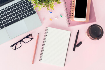 Modern pink office desk table  with  notebook for input the text in the middle. Top view, flat lay