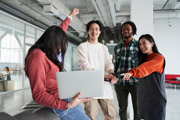 Group of international students looking at laptop