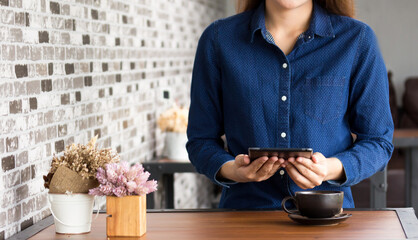 women using a digital tablet  at a coffee shop. Young man and woman looking at touch screen  and smiling.