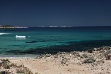 Surfers surfing the clear blue sea