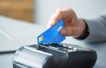 hands holding credit card typing numbers on computer keyboard while sitting at home at