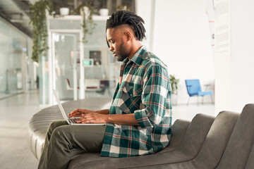 Portrait of the confident handsome multirace student man with dreadlocks