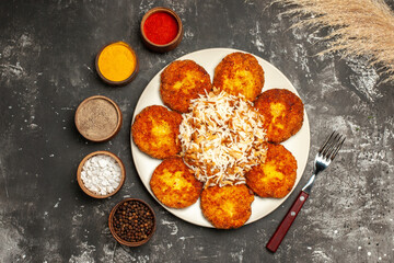 top view fried cutlets with cooked rice and seasonings on dark background food dish photo meat