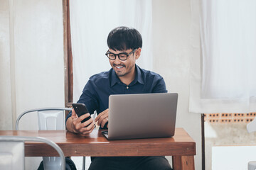Fototapeta premium man work using texting cell phone typing computer.chatting on mobile,laptop contact us at workplace Thinking investment plan Investor.searching information internet.connecting people concept