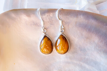 Sterling silver with natural tiger eye mineral gemstone on bright neutral background