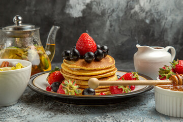front view yummy pancakes with fruits and tea on light background sweet fruit breakfast