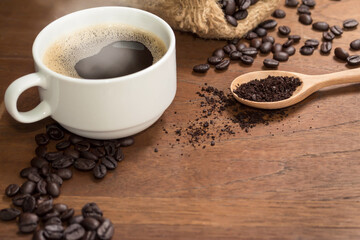 Hot Coffee cup with Coffee beans on the wooden table