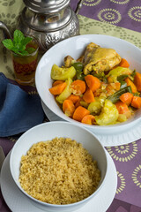 Cuscus marroquí con verduras y pollo, junto a una tetera