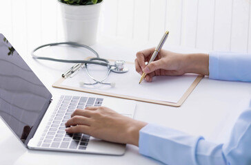 doctor working on office write report with medical stethoscope use laptop . Health care concept.telemedicine or teleconference, electronics 