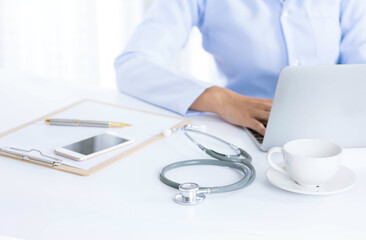 Stethoscope with clipboard and Laptop on desk,Doctor working in hospital writing a prescription, Healthcare and medical concept,