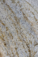 Vertical photo. The texture of the foam on the seashore from the surf.