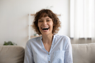 Overjoyed young pretty female laughing on cute funny joke demonstrating perfect straight white...