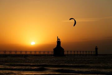 Kite boarder at sunset near lighthouse