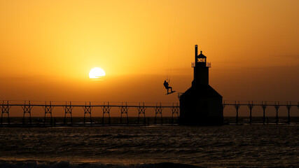 Kite boarder in air over lighthouse