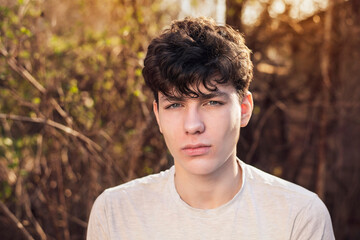 Upset young teenager rests in nature and spends his free time thinking about the future, thinking...