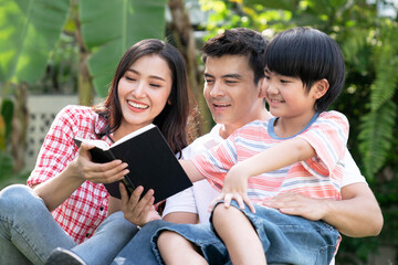 Happy family relaxes in the front lawn on a weekend together.