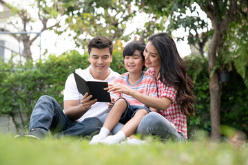 Naklejka premium Happy family relaxes in the front lawn on a weekend together.