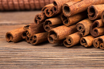 Obraz na płótnie Canvas Stack of cinnamon sticks on a wooden background. Macro photography of spices.