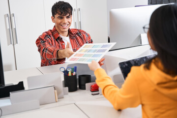 Designer giving palette of colors to her male colleague