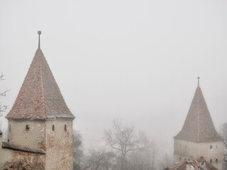 Medieval defense towers on a misty morning in Sighisoara Citadel, Romania.