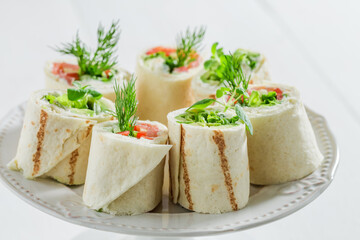 Fototapeta na wymiar Tortilla with salmon, creamy cheese and vegetables