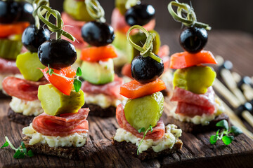 Various finger food made of meat, gherkins and olives - obrazy, fototapety, plakaty