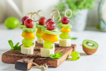 Sweet and tasty skewers with fruits and mint for party