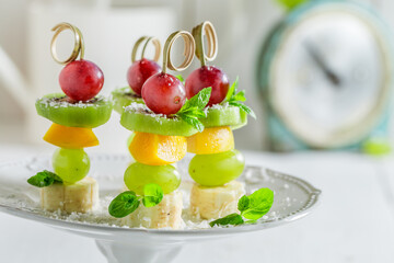 Closeup of skewers with fresh fruits, coconut and mint