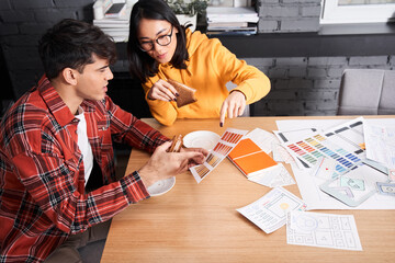 Designers sitting at the office table with samples of colors