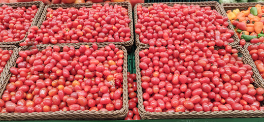 Cherry tomatoes in wooden baskets for sale in supermarket.