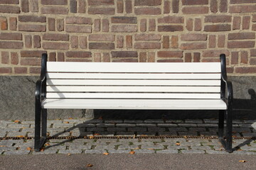 White bench on the background of brick wall