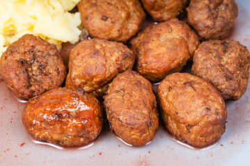 cooked swedish meatballs with lingonberry sauce and mashed potatoes on blue plate close up