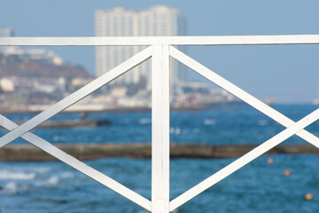 Sea view. White wooden railings of the pier.