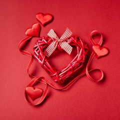Valentines day hearts and ribbon on red background. Top view with copy space. Valentine's day concept.