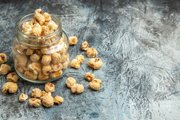 front view sweet popcorn inside glass can on a light background snack movie sugar