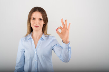 Close up beautiful young business woman showing OK with fingers