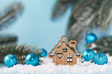 Wooden toy House on blue Christmas background. Concept staying at home. Covid