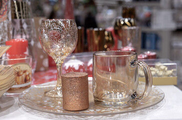 Glass tumbler, wine glass and shiny candle on the festive New Year's table.