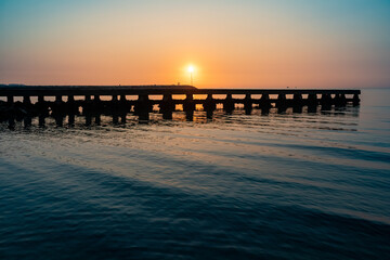 Strand mit Steg im Sonnenuntergang