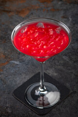 Cosmopolitan cocktail on a dark stone background, a mix of vodka, cranberry juice and lemon juice with vermouth