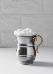 AYRAN. Traditional Turkish yoghurt drink with foam in silver metal cup.