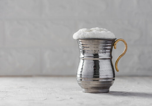 AYRAN. Traditional Turkish yoghurt drink with foam in silver metal cup.