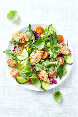 Salad with Chicken Breast, Cherry Tomatoes, Cucumber, Rocket and fresh Basil. Bright wooden background. Top view. 