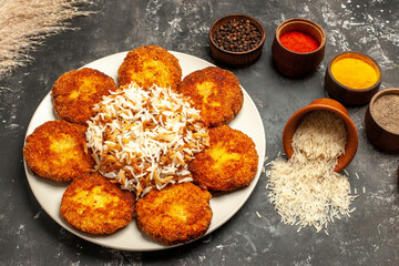 top view fried cutlets with cooked rice and seasonings on a dark background food meat dish