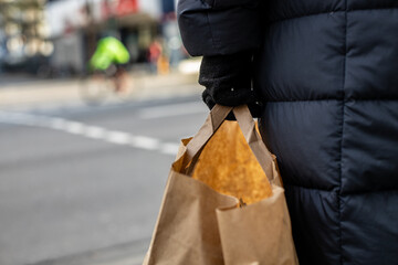 Close up in hand holding paper bag on the street