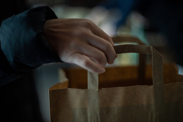 Close up in hand picking up paper bag 