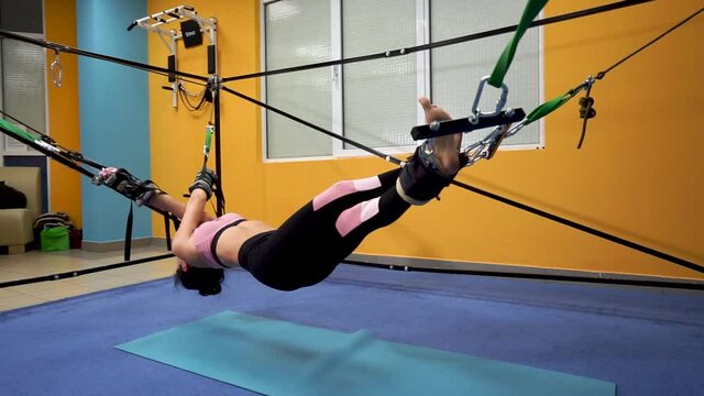 Pilates Woman In Cadillac Split Legs Stretch Exercise At Stretching on the simulator RULE
