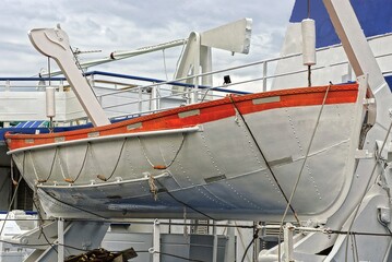 one white large lifeboat hangs aboard the cruise ship