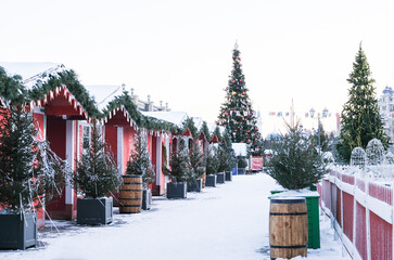 A long empty street without people with red Christmas houses, Christmas trees. Winter day. Christmas market