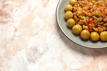 bottom view roasted eggplant salad and pickled plums on plate on nude background free space